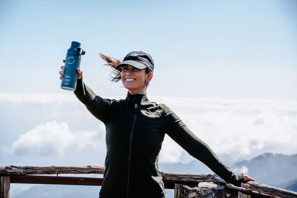 Fitness runner staying hydrated with water bottle during long training session in Arizona