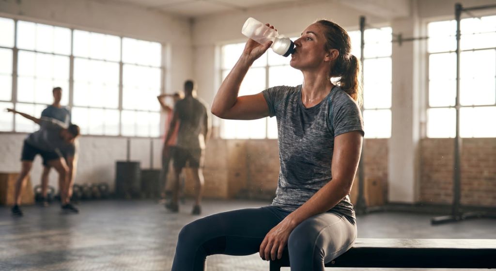 Sports recovery scene with hydration, foam rolling, and rest after workout in Colorado